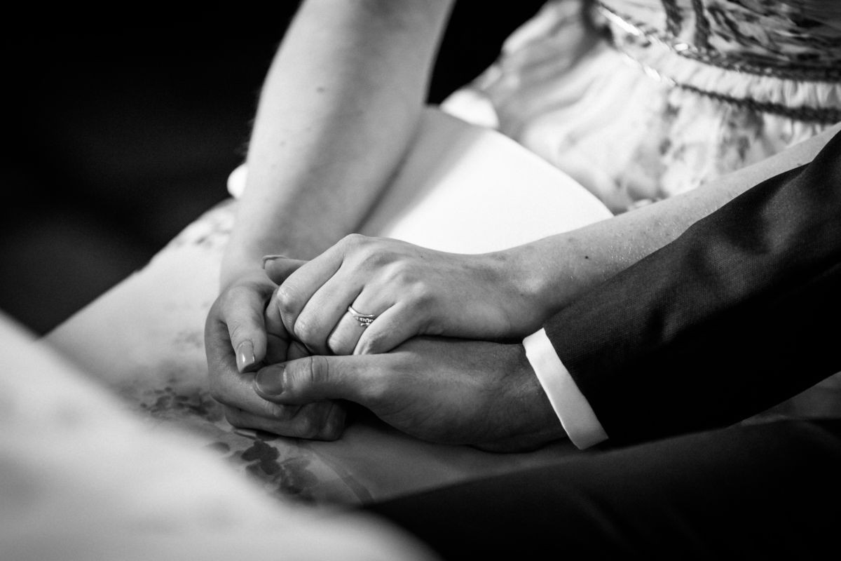 Das Brautpaar hält sich während der Trauung an den Händen: Die Hände sind in Großaufnahme zu sehen