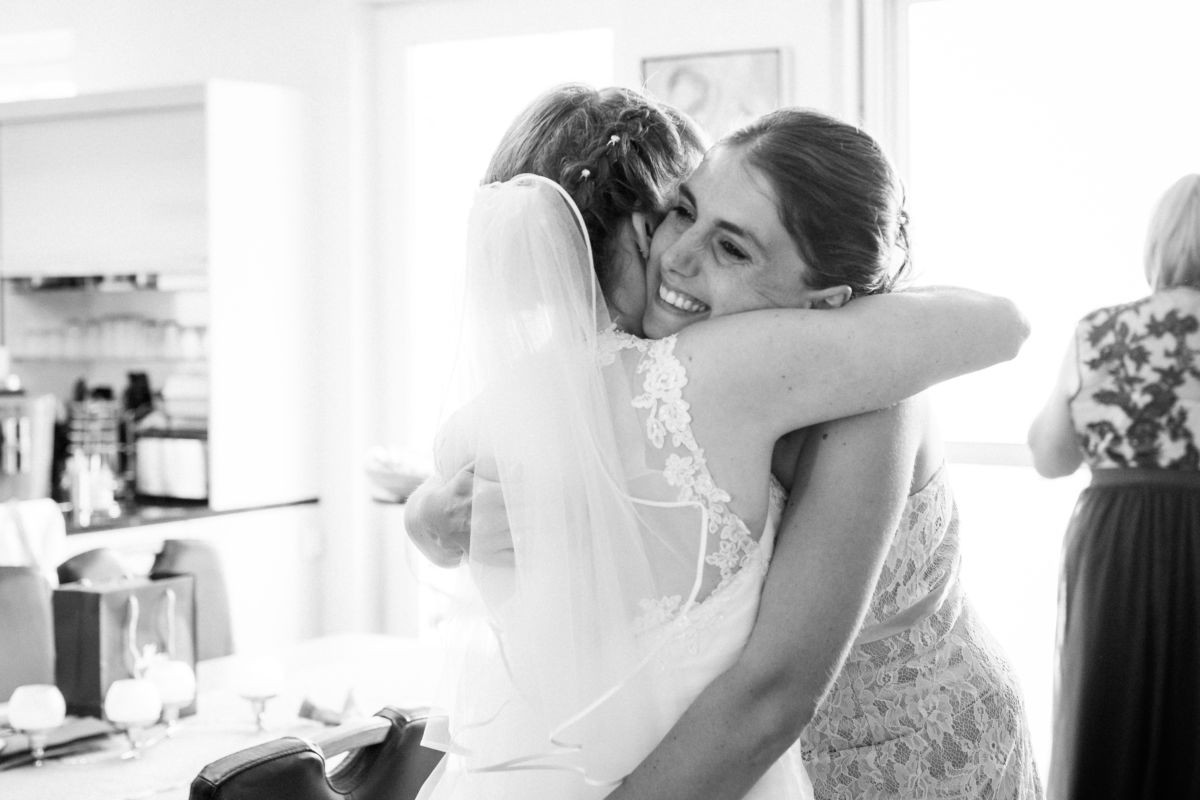 Die Braut umarmt vor ihrer Hochzeit ihre Schwester