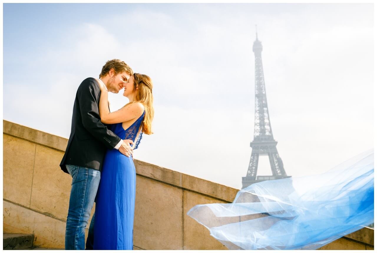 Verlobungsshooting in Paris, das Paar sieht sich vor dem Eiffelturm verliebt an.