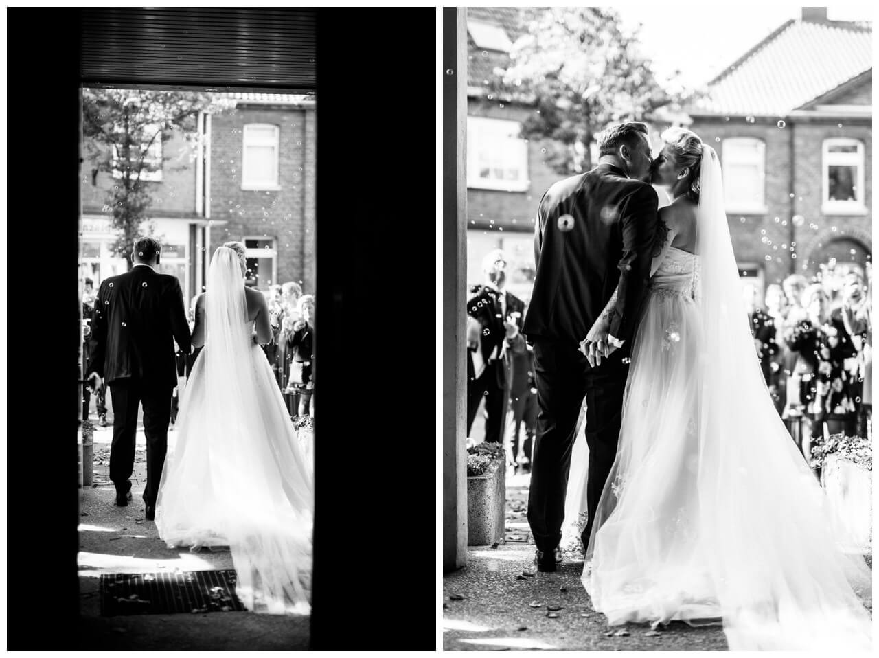 Braut und Bräutigam sind von hinten zu sehen wie sie dir Kirche nach der Hochzeit verlassen.