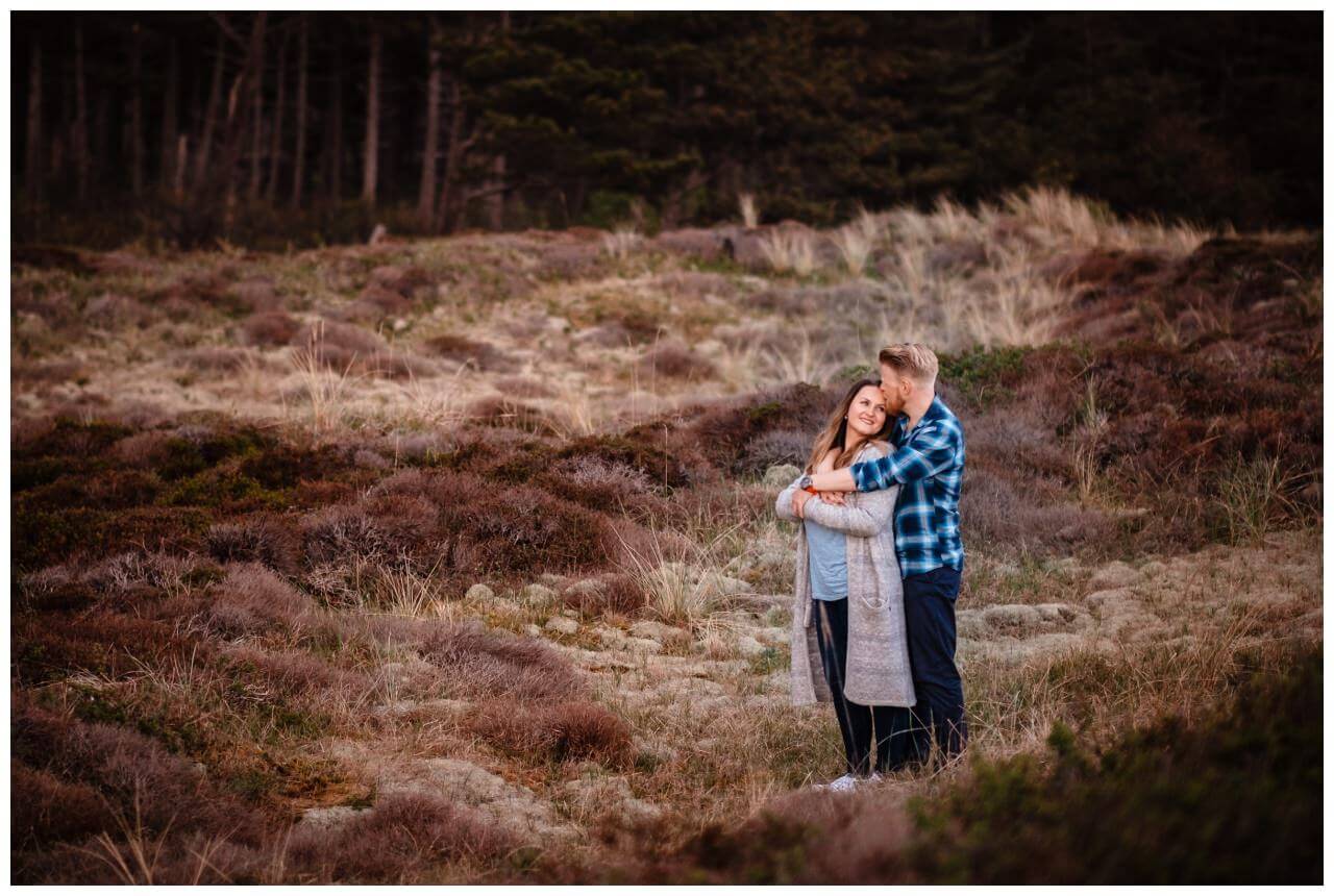 Das Brautpaar steht in der Landschaft und umarmt sich beim Paarshooting auf Texel