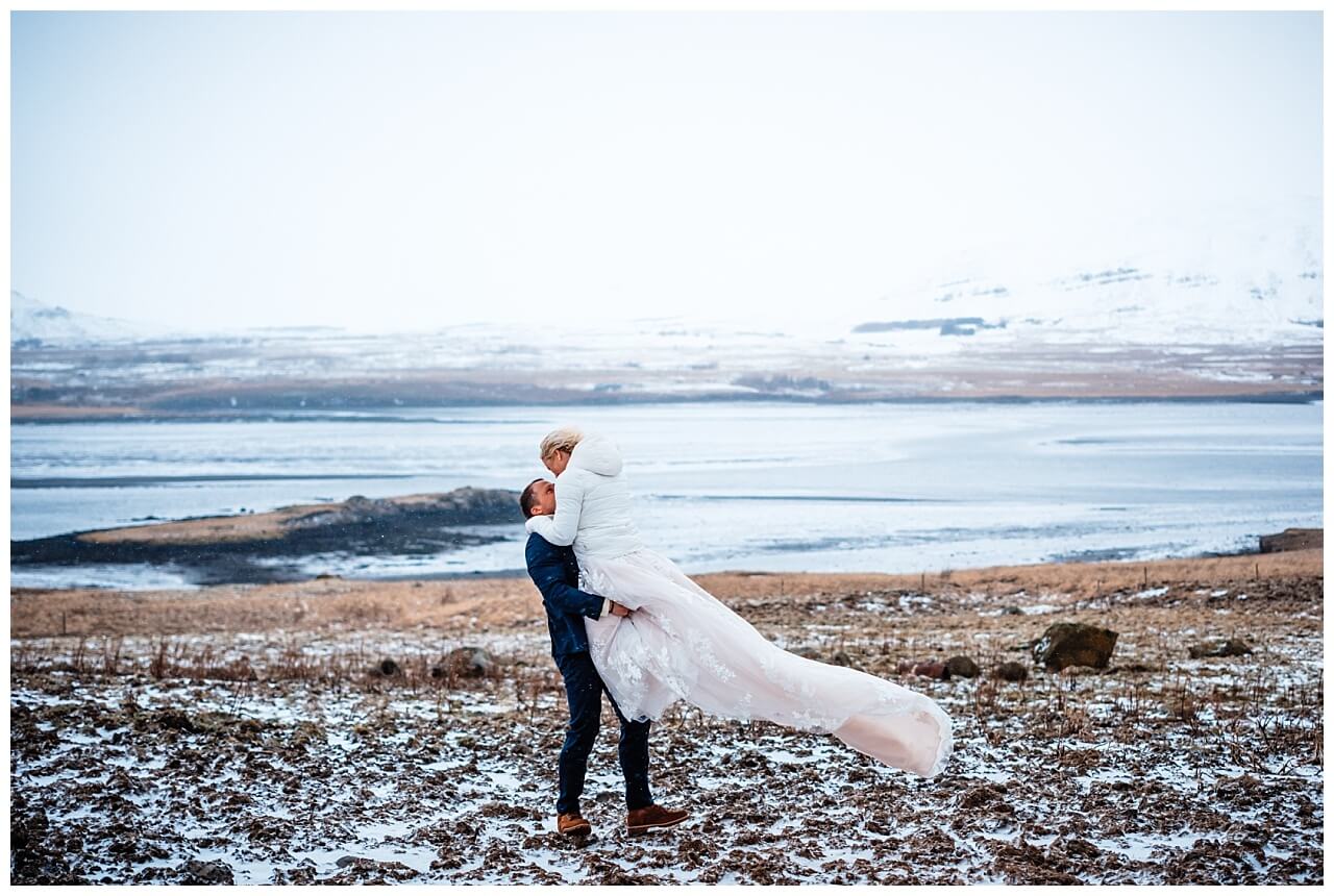 Brautpaar vor einem gefrorenen See bei ihrer Hochzeit auf Island.